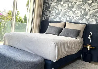 a bedroom with a bed and a wall with a window at Villa de luxe avec piscine privée au cœur de Casablanca, Maroc in Casablanca