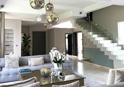 a living room with a couch and a staircase at Villa de luxe avec piscine privée au cœur de Casablanca, Maroc in Casablanca