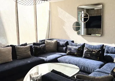 a living room with a blue couch and a table at Villa de luxe avec piscine privée au cœur de Casablanca, Maroc in Casablanca
