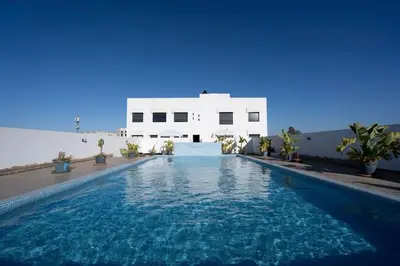 a swimming pool in front of a white building at Le Cocon d'Oasis - Location journalière Casablanca in Casablanca