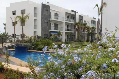 a building with a pool and flowers in front of it at BM Resort in Casablanca