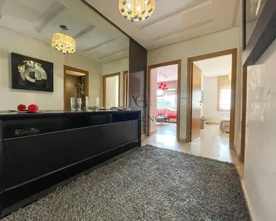 a living room with a black dresser and a hallway at Luxueux appartement Bay view dans une résidence avec magnifique jardin in Casablanca