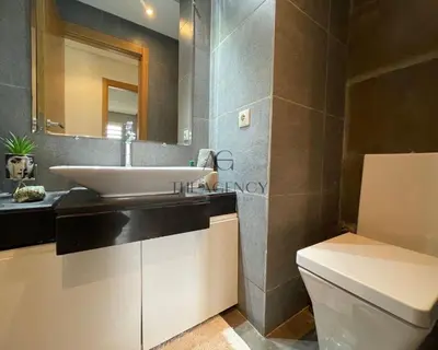 a bathroom with a sink and a toilet and a mirror at Luxueux appartement Bay view dans une résidence avec magnifique jardin in Casablanca