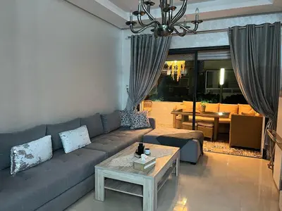 a living room with a couch and a table at Maison Bleu in Mansouria