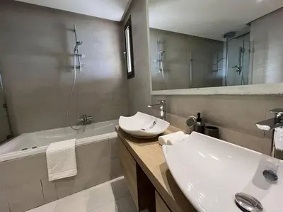 a bathroom with a sink and a tub and a mirror at Marina Love in Casablanca