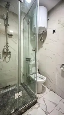 a bathroom with a glass shower and a toilet at Appartement BMK N-1 in Rabat