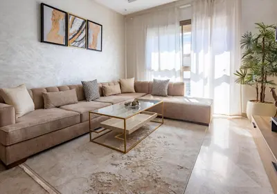 a living room with a couch and a table at Modern Charm at Le Joyau du Parc in Mohammedia