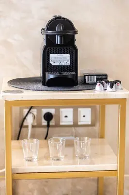 a table with a slow cooker and glasses on it at Modern Charm at Le Joyau du Parc in Mohammedia