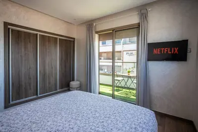 a bedroom with a bed next to a window at Modern Charm at Le Joyau du Parc in Mohammedia