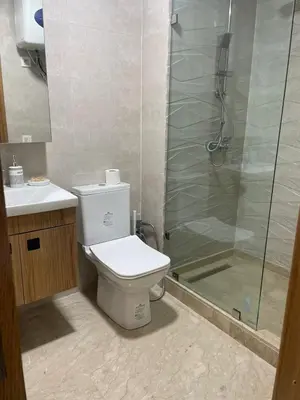 a bathroom with a toilet and a glass shower at Studio meublé neuf à louer in Casablanca