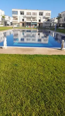 a large swimming pool in front of a building at Residence Puerto Banus in Mohammedia