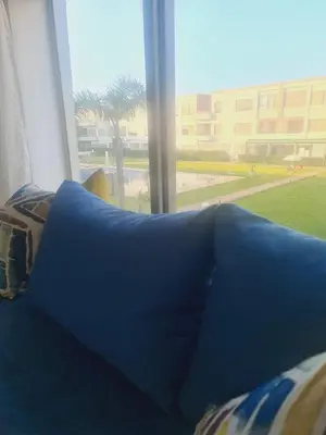 a blue couch in a room with a large window at Residence Puerto Banus in Mohammedia