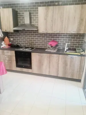 a kitchen with wooden cabinets and a stove top oven at Residence Puerto Banus in Mohammedia