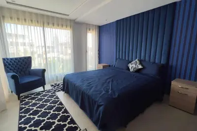 a blue bedroom with a bed and a chair at Villa Jack Beach in Tamaris