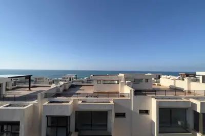 an apartment building with the ocean in the background at Villa Jack Beach in Tamaris