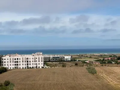 a large white building with the ocean in the background at Appartement vue sur mer sidi Rahal in Sidi Rahal