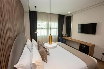 a hotel room with a bed and a tv at Le M Hôtel in Rabat