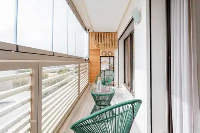 a balcony with two green chairs on it at StayInn - Studio luxueux & cosy avec terrasse aménagée in Casablanca