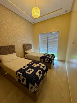 a bedroom with two beds and a window at CASA BAY BEACH OMK 2 in Sidi Rahal