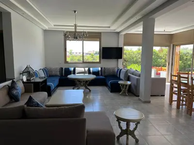 a living room with couches and tables and a couch at Maison de Campagne in Dar SaÃ¯d Ben Hajj