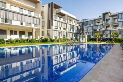 a swimming pool in front of a apartment building at Appartement - Dar Bouazza spacieux avec piscine à Dar Bouazza in Dar Bouazza