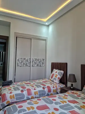 a bedroom with two beds and a headboard at Appartement - Dar Bouazza spacieux avec piscine à Dar Bouazza in Dar Bouazza