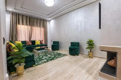 a living room with a green couch and a fireplace at Appartement - Dar Bouazza spacieux avec piscine à Dar Bouazza in Dar Bouazza