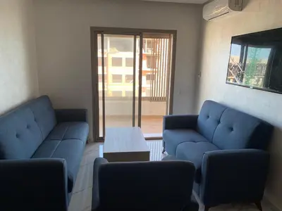 a living room with two blue couches and a table at Zenata Tower in Casablanca