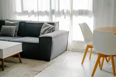 a living room with a black couch and a table at Best location, 2 minute to beach in Casablanca