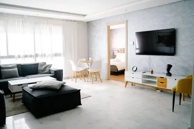 a living room with a couch and a tv at Best location, 2 minute to beach in Casablanca