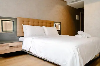 a bedroom with a large bed with white sheets and pillows at Best location, 2 minute to beach in Casablanca