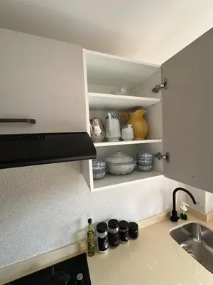 a kitchen with a sink and a shelf with pots and pans at North Beach Plage & Confort in Mansouria