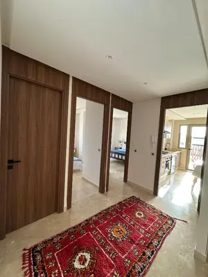 a living room with a red rug on the floor at North Beach Plage & Confort in Mansouria