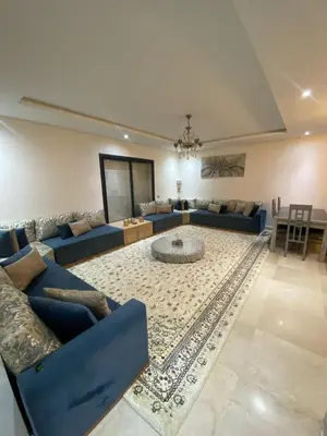a living room with blue couches and a rug at Prestigia Appartement Luxueux in Rabat