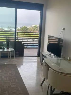 a living room with a view of the ocean at Nice appartement pool & sea view in Dar Bouazza