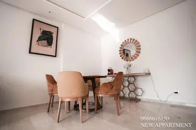 a dining room with a table and chairs and a mirror at New prestigia in Rabat