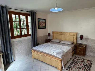 a bedroom with a large bed and a window at Rez-de-jardin à Mohammedia in Mohammedia