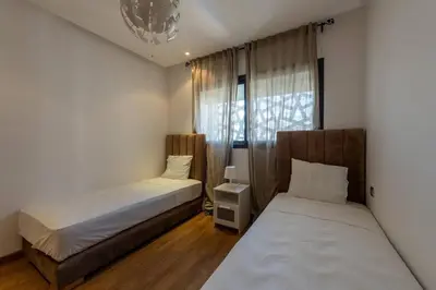 a bedroom with two beds and a window at Très bel appartement bien situé Hayriad in Rabat