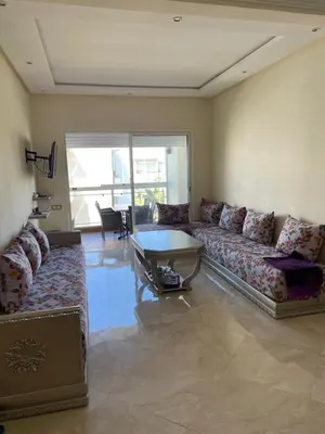 a living room with a couch and a table at Appartement à Casabay SidiRahal in Sidi Rahal
