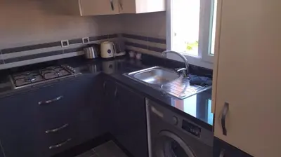 a kitchen with a sink and a stove at Résidence Al Kawtar- Mansouria Mohammedia in Mohammedia