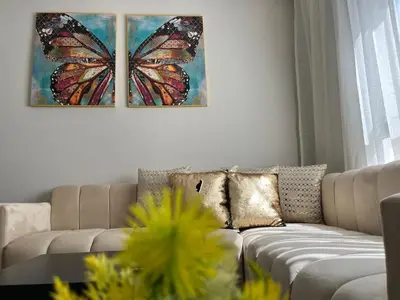 a living room with a couch and a butterfly painting on the wall at Comfy & Modern Studio at blv Anfa in Casablanca