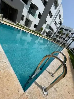 a swimming pool with a metal object in front of a building at Étoile Harhoura in El Harhoura