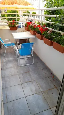 a table and chairs on a balcony with plants at Tamesna HOUSE in Sidi Yahia az Zaʼer