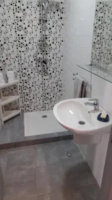 a white bathroom with a sink and a shower at Tamesna HOUSE in Sidi Yahia az Zaʼer