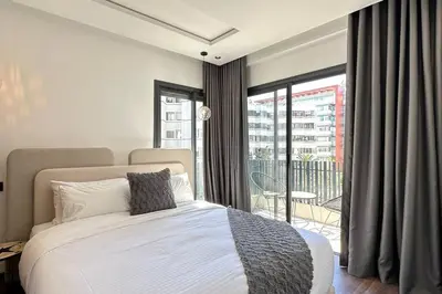 a bedroom with a large bed and a balcony at Luxurious 2 Suites Apt - By AppartAli in Casablanca