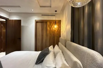 a bedroom with a bed with white sheets and pillows at Luxurious 2 Suites Apt - By AppartAli in Casablanca