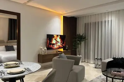a living room with a couch and a table and a tv at Sunny 2 Bedrooms - By AppartAli in Casablanca