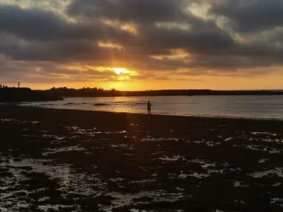a person standing on the beach at sunset at chez mehdi in Skhirat