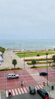 a parking lot with cars parked next to the ocean at Atlantic Suite View 3 in Casablanca