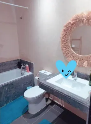 a bathroom with a toilet and a sink and a mirror at Appartement luxueux et moderne à sidi Rehal in Dar Hamida